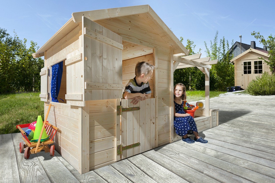 Ein Mädchen und ein Junge spielen in einem kleinen Kinderspielhaus aus Holz