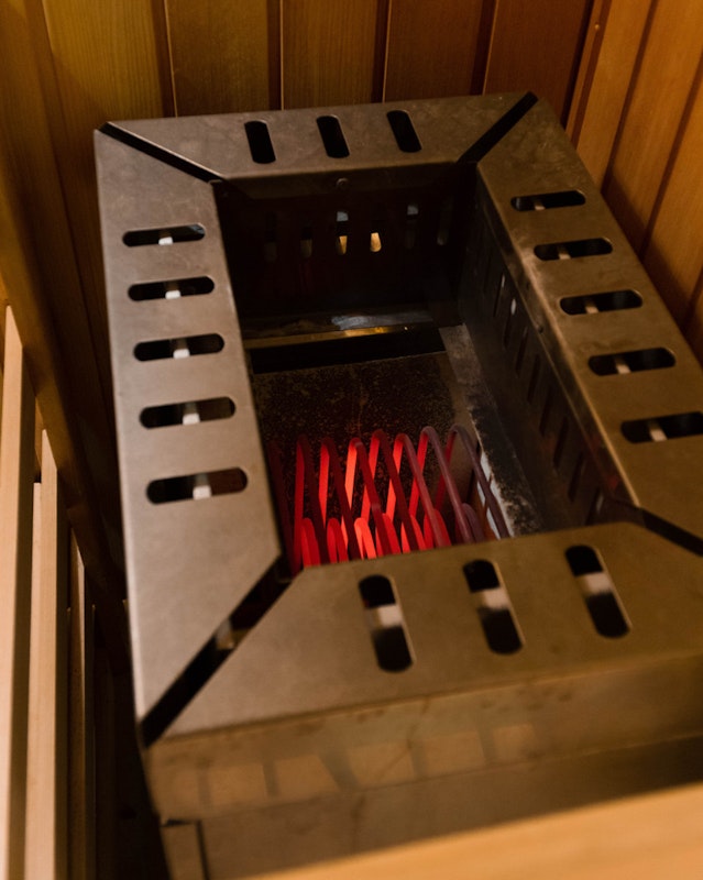Glühende Heizstäbe in einem alten Saunaofen. Der Ofen sollte nie betrieben werden, wenn keine Steine darin aufgeschichtet sind!