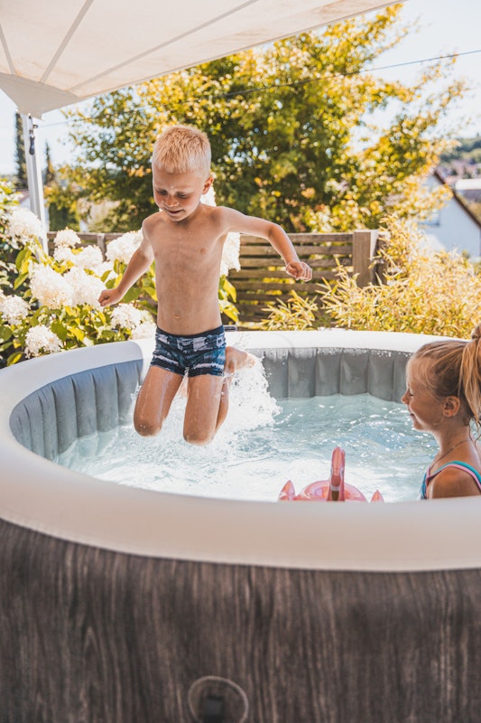 Kinder spielen in einem Whirlpool auf der Terrasse