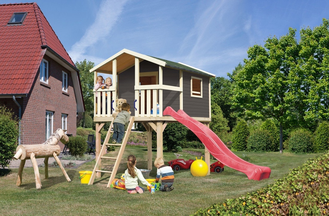 Vier Kinder spielen in einem Kinderspielhaus aus Holz