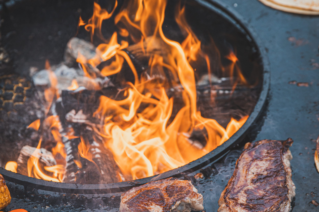 Auf einer Feuerplatte werden zwei saftige Steaks gebraten