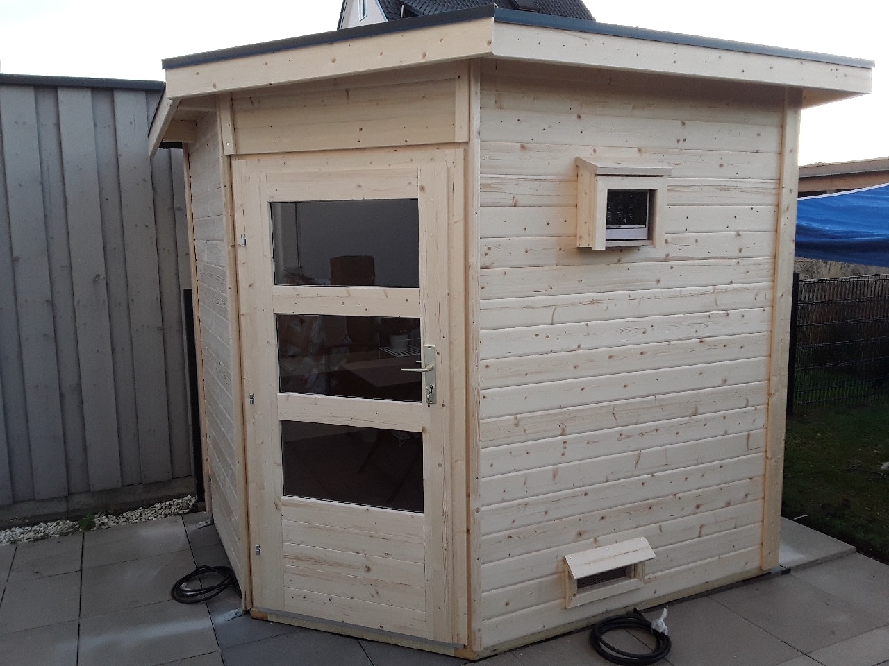 Von einem Kunden aufgenommenes Foto von Karibu Gartensauna Pultdach Saunahaus Mikka mit Eckeinstieg naturbelassen inkl. 9-teiligem gratis Zubehörpaket Von einem Kunden aufgenommenes Foto von Karibu Gartensauna Pultdach Saunahaus Mikka mit Eckeinstieg naturbelassen inkl. 9-teiligem gratis Zubehörpaket